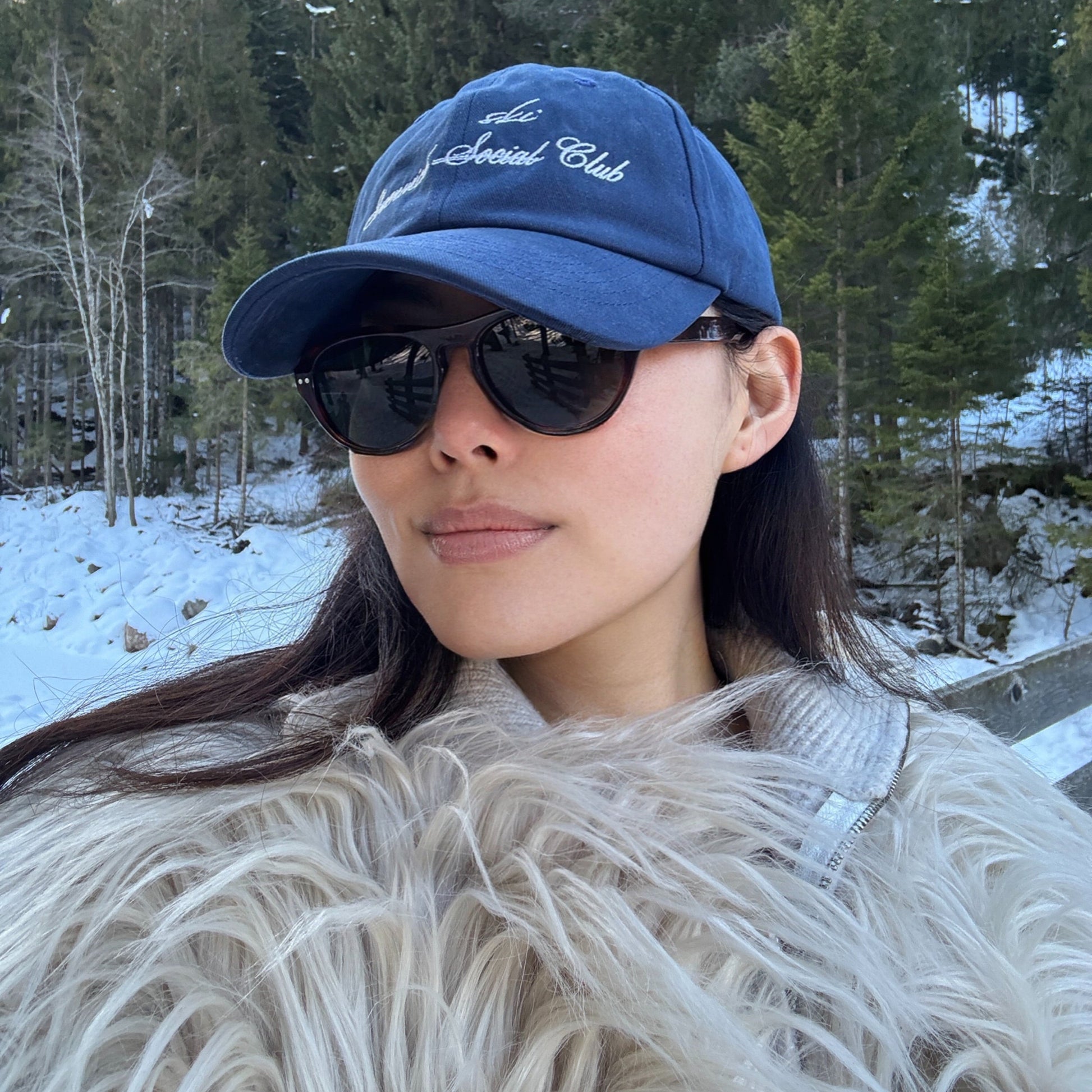 Model wearing Ciren oval tortoiseshell sunglasses and wearing Greenwich Social Club logo baseball cap